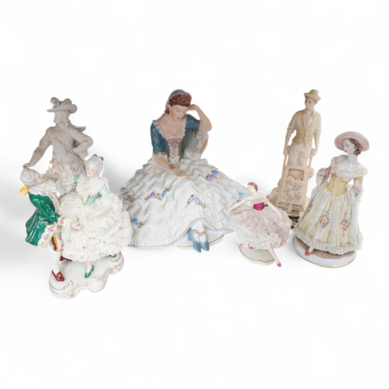 A Royal Dux porcelain figure of a seated lady wearing a ballgown, together with sundry ornaments to include Dresden lace porcelain figure group, largest 33cm wide
